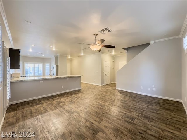 unfurnished living room with crown molding, dark wood finished floors, baseboards, a ceiling fan, and a sink