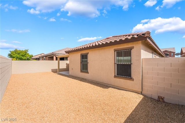 4436 Hatch Bend Ave, North Las Vegas, NV 89031 - back of house featuring a fenced backyard, stucco siding, a patio area, and a tiled roof