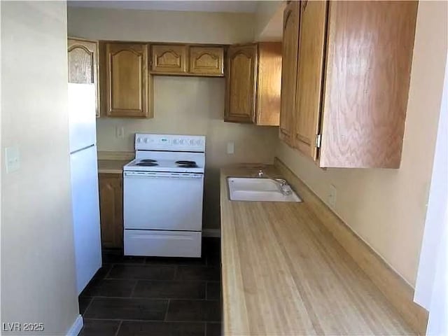 kitchen with a sink, brown cabinets, white appliances, and light countertops