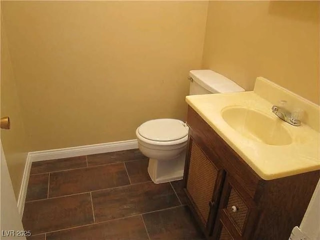bathroom with vanity, baseboards, tile patterned floors, and toilet