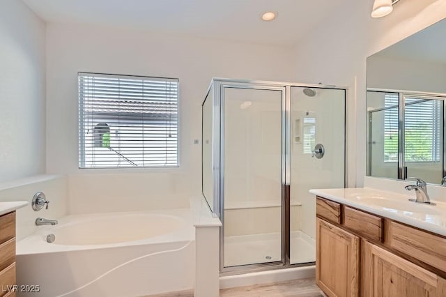 full bathroom with vanity, a shower stall, healthy amount of natural light, and a garden tub