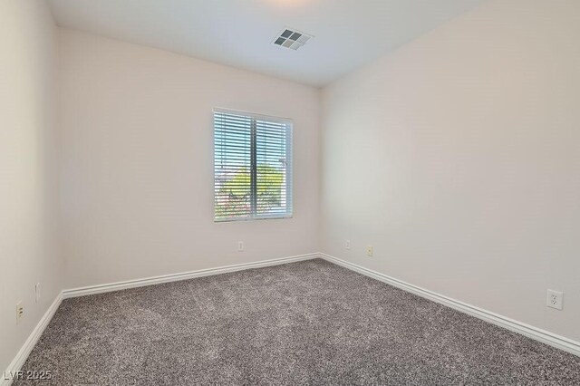 carpeted empty room featuring baseboards