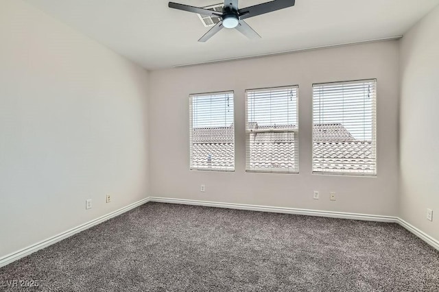 carpeted empty room with a ceiling fan and baseboards