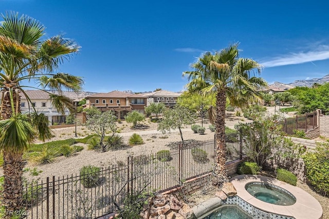 view of swimming pool with an in-ground hot tub and fence