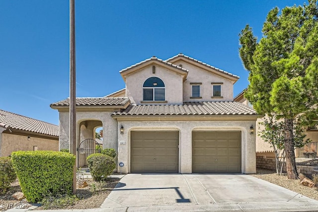 mediterranean / spanish-style home featuring a tiled roof, an attached garage, stucco siding, concrete driveway, and fence