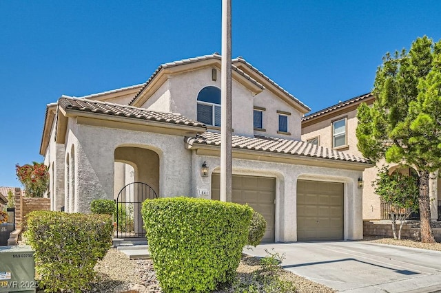 mediterranean / spanish house with driveway, stucco siding, and a tile roof
