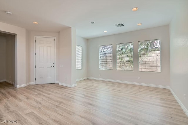 empty room featuring recessed lighting, light wood finished floors, baseboards, and a smoke detector