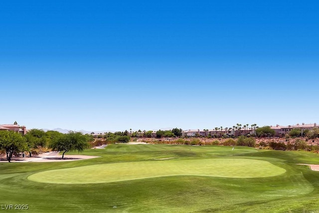 surrounding community with view of golf course, a putting area, and a mountain view