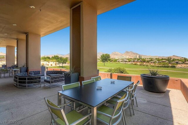 view of patio with outdoor dining area and a mountain view