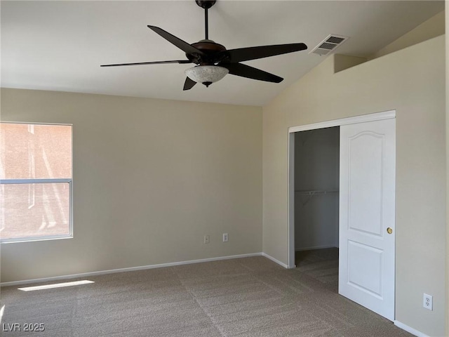 unfurnished bedroom featuring a closet, carpet, baseboards, visible vents, and vaulted ceiling
