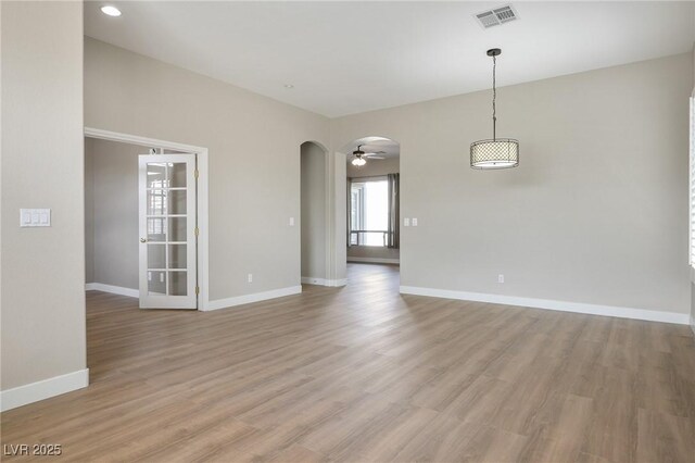 3278 Turning Bridge St, Las Vegas, NV 89135 - empty room with arched walkways, a ceiling fan, baseboards, light wood-type flooring, and visible vents