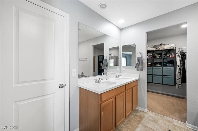 5631 Hill Cliff Ct, North Las Vegas, NV 89031 - bathroom with double vanity, a spacious closet, and baseboards