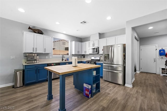 5631 Hill Cliff Ct, North Las Vegas, NV 89031 - kitchen featuring stainless steel appliances, butcher block counters, blue cabinets, white cabinets, and recessed lighting