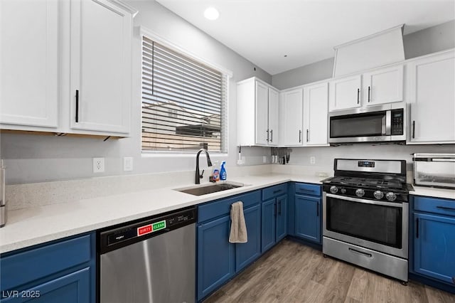 5631 Hill Cliff Ct, North Las Vegas, NV 89031 - kitchen featuring appliances with stainless steel finishes, a sink, blue cabinetry, and white cabinets