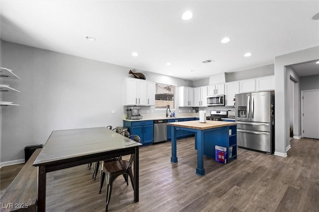 5631 Hill Cliff Ct, North Las Vegas, NV 89031 - kitchen featuring appliances with stainless steel finishes, butcher block countertops, blue cabinetry, white cabinetry, and recessed lighting