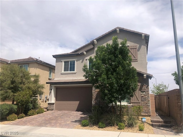 view of front of house featuring stucco siding, decorative driveway, stone siding, and a garage