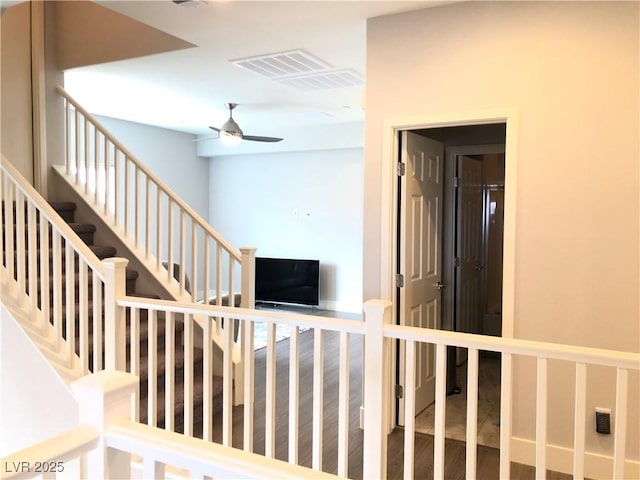 stairs featuring ceiling fan, visible vents, and wood finished floors