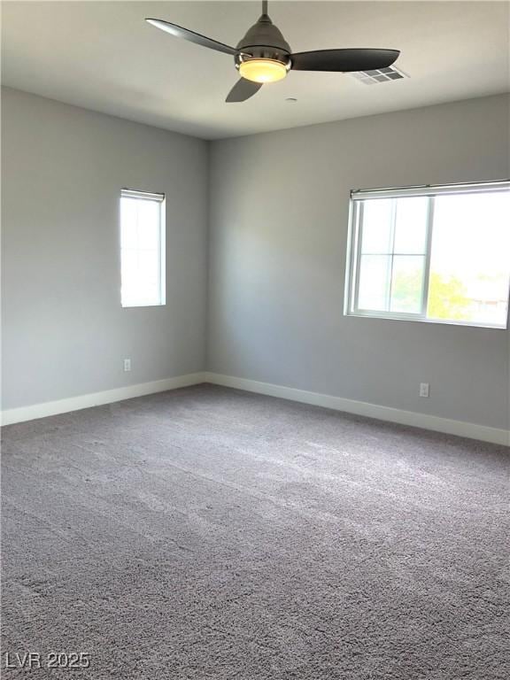 carpeted spare room with ceiling fan, visible vents, and baseboards
