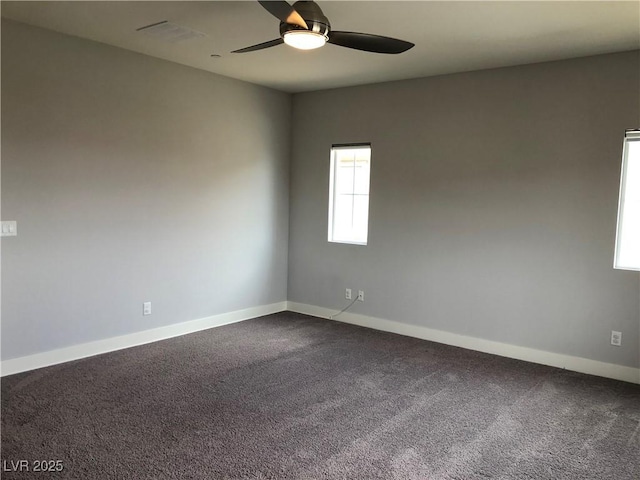 carpeted spare room with baseboards, a ceiling fan, and visible vents