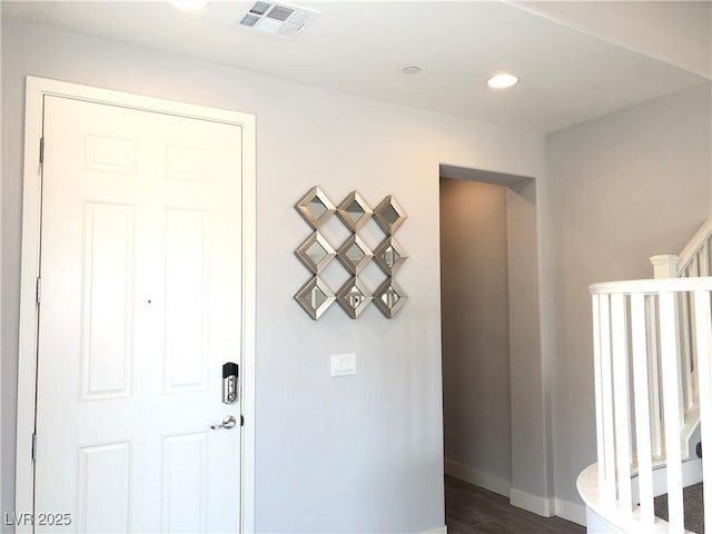 hallway with visible vents, dark wood finished floors, stairs, baseboards, and recessed lighting