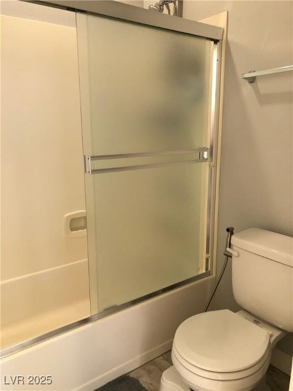 full bath featuring toilet and shower / bath combination with glass door