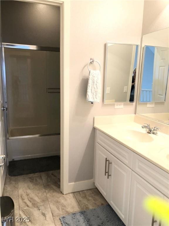 full bathroom featuring baseboards, enclosed tub / shower combo, and vanity