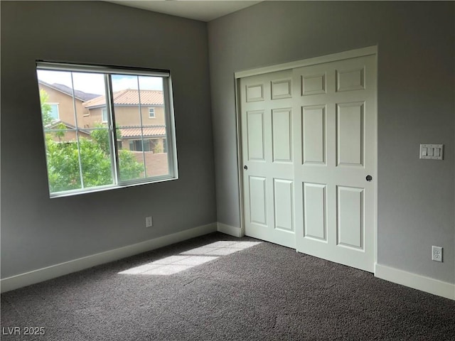 unfurnished bedroom featuring a closet, carpet flooring, and baseboards