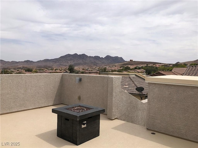 view of patio / terrace featuring a fire pit, a mountain view, and a balcony
