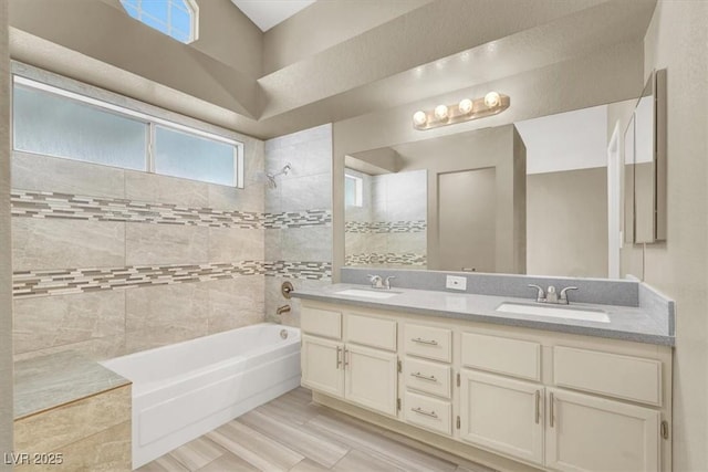 bathroom with double vanity, a sink, and bathing tub / shower combination
