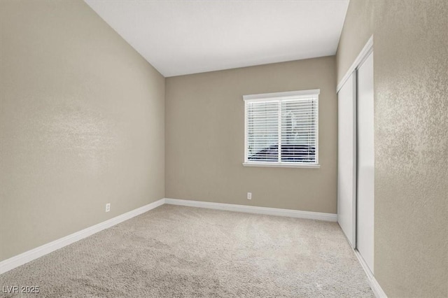 unfurnished room featuring baseboards and carpet