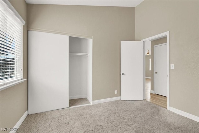 unfurnished bedroom featuring a closet, carpet, and baseboards