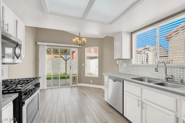 kitchen featuring a sink, appliances with stainless steel finishes, tasteful backsplash, and baseboards