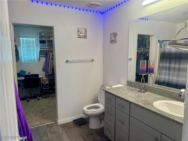 2872 Atomic Tangerine Way Unit 2, Las Vegas, NV 89183 - bathroom with a walk in closet, vanity, and wood finished floors