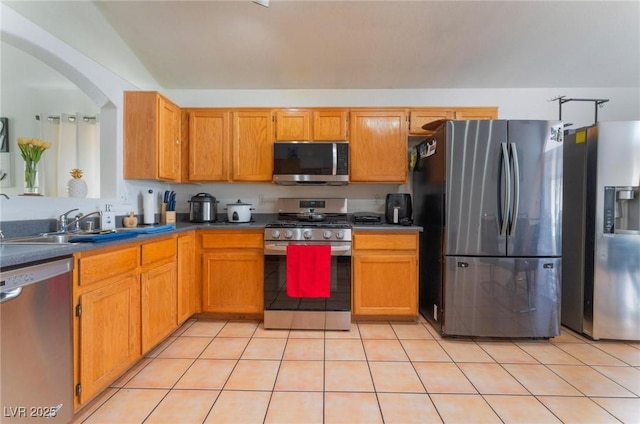 2903 Galena Peak Ln, Las Vegas, NV 89156 - kitchen featuring a sink, arched walkways, light tile patterned floors, and stainless steel appliances
