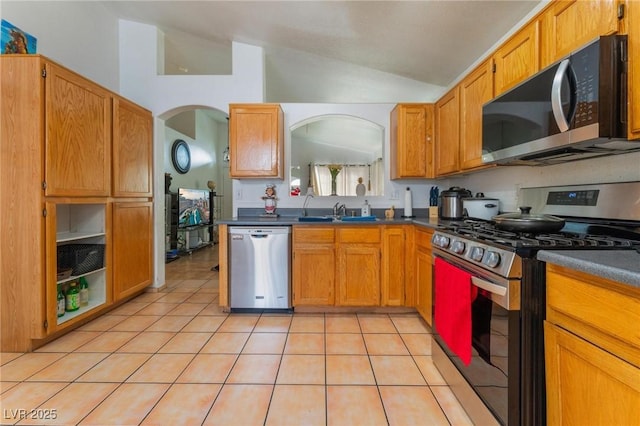 2903 Galena Peak Ln, Las Vegas, NV 89156 - kitchen featuring appliances with stainless steel finishes, dark countertops, arched walkways, a sink, and lofted ceiling