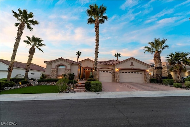 2742 Darby Falls Dr, Las Vegas, NV 89134 - mediterranean / spanish-style home featuring an attached garage, stone siding, stucco siding, and concrete driveway