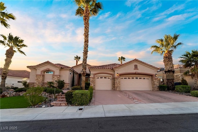 2742 Darby Falls Dr, Las Vegas, NV 89134 - mediterranean / spanish home featuring stone siding, stucco siding, an attached garage, driveway, and a tile roof
