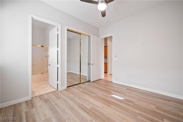 unfurnished bedroom with ceiling fan, light wood-style flooring, baseboards, ensuite bathroom, and a closet