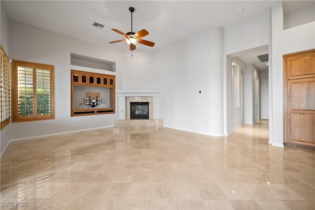 2742 Darby Falls Dr, Las Vegas, NV 89134 - unfurnished living room featuring ceiling fan, baseboards, a fireplace, and a towering ceiling
