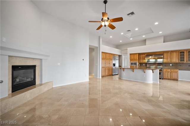 2742 Darby Falls Dr, Las Vegas, NV 89134 - unfurnished living room with a ceiling fan, a towering ceiling, recessed lighting, baseboards, and a high end fireplace