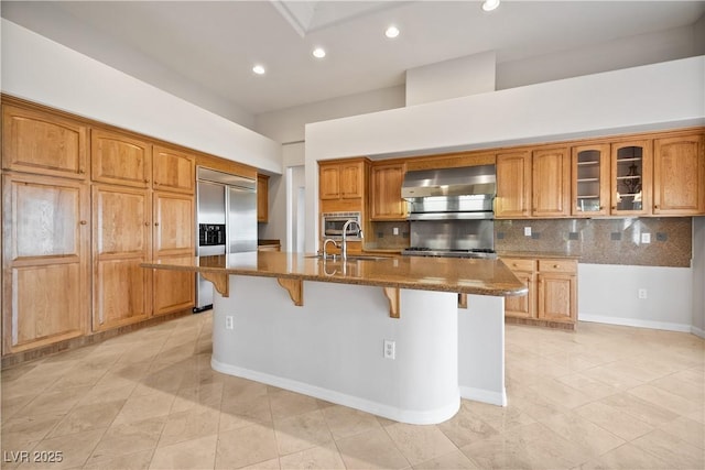 2742 Darby Falls Dr, Las Vegas, NV 89134 - kitchen with wall chimney range hood, built in appliances, light tile patterned floors, dark stone counters, and backsplash