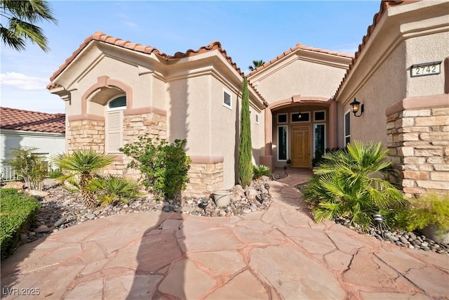 2742 Darby Falls Dr, Las Vegas, NV 89134 - property entrance featuring stone siding, a tiled roof, stucco siding, and a patio area