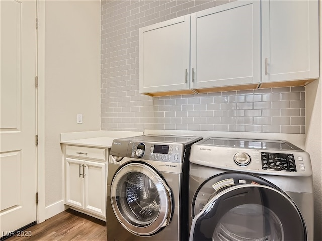 3008 Barrett Springs Ave, Henderson, NV 89044 - clothes washing area featuring baseboards, washer and clothes dryer, cabinet space, and wood finished floors