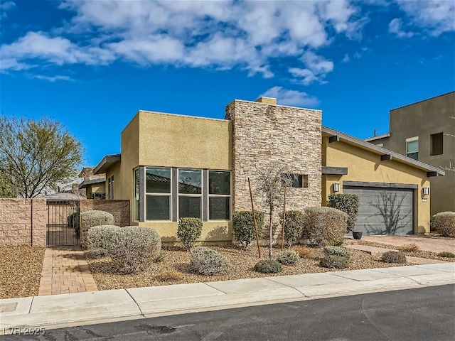 3008 Barrett Springs Ave, Henderson, NV 89044 - view of front of house with driveway, a gate, an attached garage, stone siding, and stucco siding