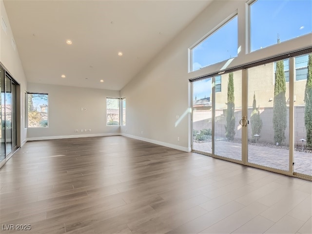 3008 Barrett Springs Ave, Henderson, NV 89044 - unfurnished living room with wood finished floors, recessed lighting, baseboards, and a high ceiling