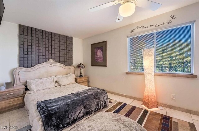 bedroom featuring a ceiling fan, baseboards, and light tile patterned floors
