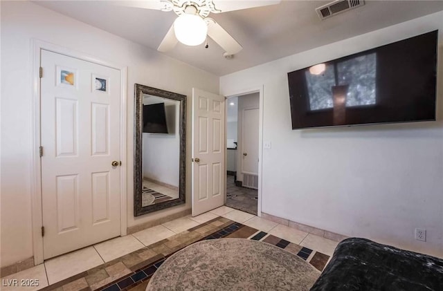 tiled bedroom with baseboards, ceiling fan, and visible vents