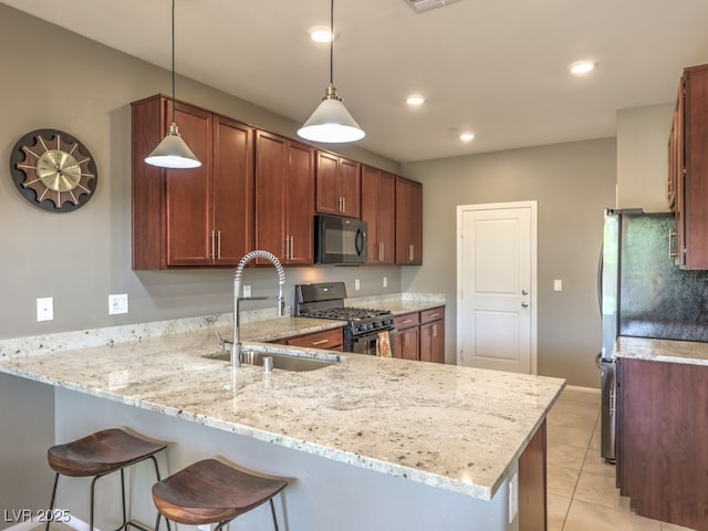 kitchen featuring light stone counters, a sink, a peninsula, and black appliances