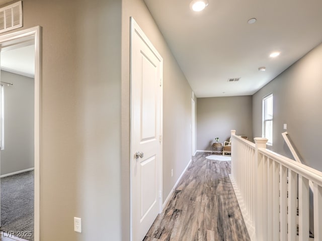 hall with visible vents, recessed lighting, baseboards, and an upstairs landing
