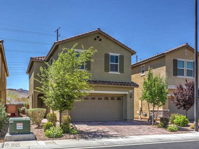 mediterranean / spanish-style house featuring a garage, a tiled roof, driveway, and stucco siding
